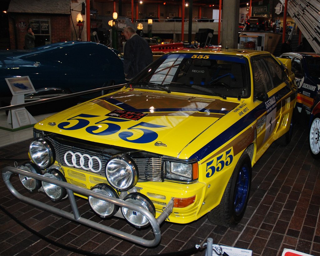 Audi Quattro amarelo em museu com faróis de rally